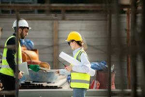 Engineer and architect working on the construction site, double-checking plans and process. photo