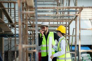 Engineer and architect working on the construction site, double-checking plans and process. photo