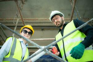 Engineer and architect working on the construction site, double-checking plans and process. photo