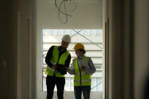 ingeniero y arquitecto trabajando en el construcción sitio, doble revisión planes y proceso. foto