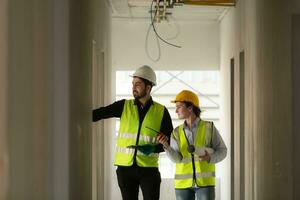 Engineer and architect working on the construction site, double-checking plans and process. photo