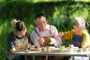 In the pottery workshop, an Asian retired couple is engaged in pottery making and clay painting activities. photo