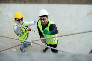 Overhead view on a building site, an engineer and architect are discussing on a laptop. photo