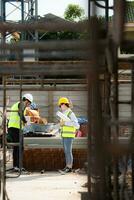 Engineer and architect working on the construction site, double-checking plans and process. photo