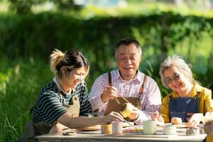 In the pottery workshop, an Asian retired couple is engaged in pottery making and clay painting activities. photo