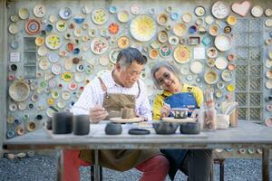 en el cerámica taller, un asiático retirado Pareja es comprometido en cerámica haciendo y arcilla pintura actividades. foto