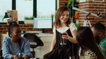 Woman talking with BIPOC apartment party guests during weekend gathering, rolling her eyes while gossiping about annoying friend. Multiethnic group of people listening to frustrated host venting video