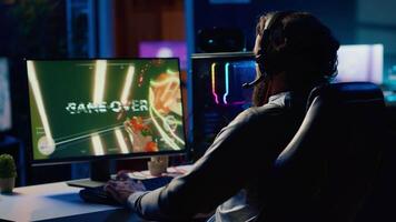 gamer kasta hörlurar i frustration efter tar emot spel över skärm i först person skytt. spelare upprörd efter varelse besegrade i TV-spel, förlorande Allt hälsa, brist till vinna nivå video
