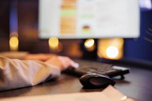 Businesswoman analyzing financial growth report, typing company strategy on computer keyboard. Executive manager working late at night at marketing project in startup office. Close up photo