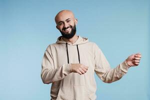 alegre árabe hombre promoviendo producto y participación invisible bandera para anuncios retrato. sonriente persona fingiendo a llevar cartel en dos manos y mirando a cámara con contento expresión foto