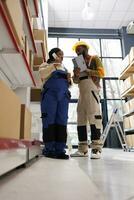 Warehouse operators checking inventory and talking on phone with logistics manager. African american factory storehouse workers speaking with freight distribution department on landline telephone photo