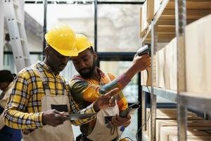 africano americano almacén gerentes exploración parcelas antes de envío. enviar oficina almacén trabajadores haciendo mercancías inventario utilizando escáner y comprobación código de barras en digital tableta foto