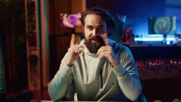 innehåll skapare spelar Videospel leva medan chattar med uppkopplad publik från neon belyst lägenhet. proffs gamer strömning multiplayer spel medan diskuterar hans strategier med tittare video