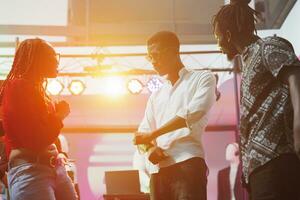 Young couple socializing and dancing in nightclub illuminated with vibrant stage spotlights. African american people clubbing and showing improvised moves on dancefloor at discotheque photo