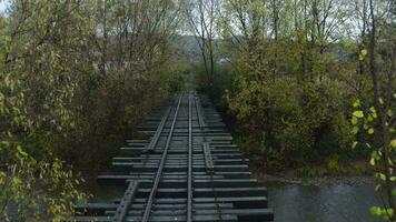 vecchio ferrovia ponte al di sopra di un' fiume. fuco volo al di sopra di ponte di vecchio stretto valutare ferrovia video