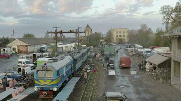 UKRAINE, UZHGOROD - June 2022. A train travels through a clothing market in the city of Uzhgorod, Ukraine. video