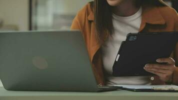 bedrijf team werken met nieuw opstarten project plan en discussie informatie voor financieel strategie met laptop en digitaal tablet in een modern bedrijf salon. video