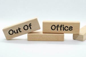Out of office text on wooden blocks with white background. Out of office concept photo
