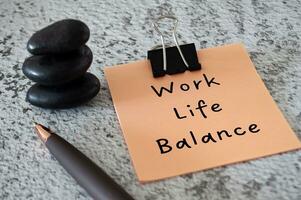 Work Life Balance text on sticky notes with stacked zen stones and pen. Working culture concept photo