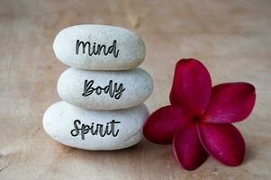 Mind, Body and Soul text engraved on white zen stones. Meditation and spa concept photo