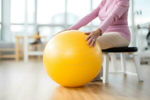 AI generated Caucasian senior doing exercise with a swiss ball at a gym photo