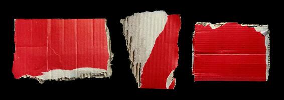 Set of ripped red cardboard pieces isolated on black background photo