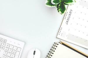 Top view of January calendar page. First month of new year on desk in white background. concept for planning and working goals in organization, cost, and income planning for startup new year photo