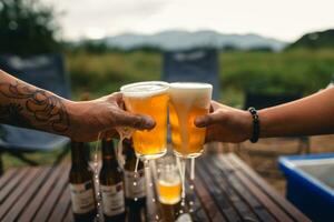 Beer on the table and camping party,hands toasting in beer, photo