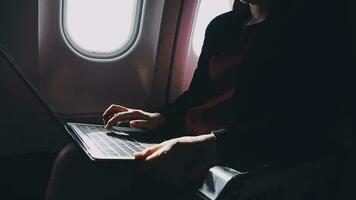 Asian young woman using laptop sitting near windows at first class on airplane during flight,Traveling and Business concept video