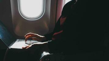 Asian young woman using laptop sitting near windows at first class on airplane during flight,Traveling and Business concept video
