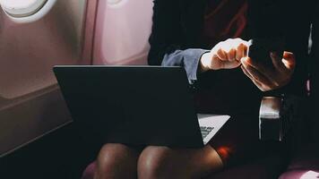asiatisk ung kvinna använder sig av bärbar dator Sammanträde nära fönster på först klass på flygplan under flyg, resor och företag begrepp video