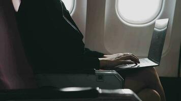 Asian young woman using laptop sitting near windows at first class on airplane during flight,Traveling and Business concept video