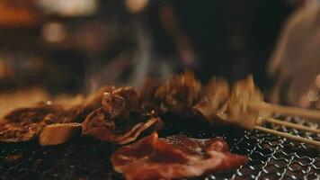 festa para churrasco japonês estilo, yakiniku. carnes estão ser cozinhou em fogão dentro uma japonês video