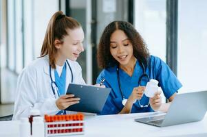 Doctor Talks With Professional Head Nurse or Surgeon, They Use Digital tablet Computer. Diverse Team of Health Care Specialists Discussing Test Result photo