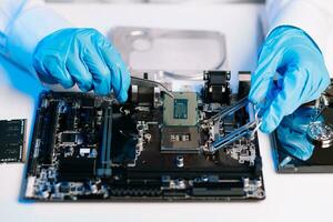 The technician repairing the motherboard in the lab with copy space. the concept of computer hardware, mobile phone, electronic, repairing, upgrade photo