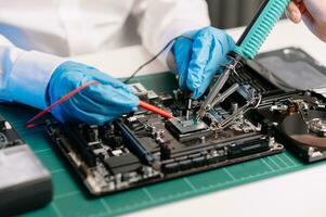 The technician repairing the motherboard in the lab with copy space. the concept of computer hardware, mobile phone, electronic, repairing, upgrade photo