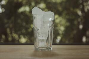 Close up of transparent square ice cubes for drinks in glass. photo