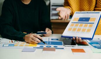 UX developer and ui designer brainstorming about mobile app interface wireframe design with customer breif and color code photo