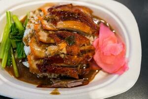 Roasted bbq duck with gravy sauce on top of rice photo