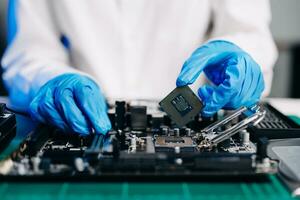 The technician is putting the CPU on the socket of the computer motherboard. electronic engineering electronic repair, electronics measuring and testing, repair photo