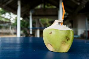 Coconut fruit drink with a orange plastic straw. Fresh coconut drink. Real coconut drink photo