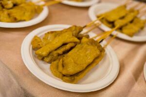 Moo satay or pork satay on white paper dish. photo