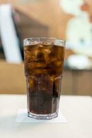 A glass of cold soft drink with ice photo