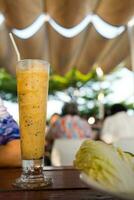 Passion fruit smoothie in tall glass, delicious tropical smoothie drink photo