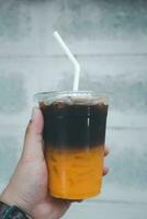 A glass of coffee mix orange juice with ice photo