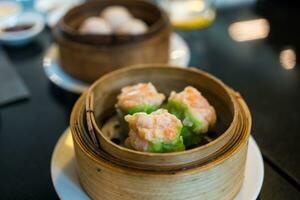 Hot steamed shrimp dumplings look delicious, dumplings recipe wrapped by green wonton wrapper photo