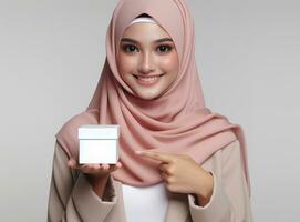 AI generated asian woman wearing hijab hold a white box isolated on white background photo
