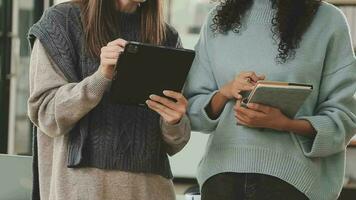 bedrijf team werken met nieuw opstarten project plan en discussie informatie voor financieel strategie met laptop en digitaal tablet in een modern bedrijf salon. video