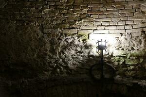 Lighted medieval castle torch hanging on a stone wall, vintage objects photo