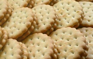 Detailed picture of round sandwich cookies with coconut filling. Background image of a close-up of several treats for tea photo